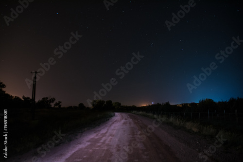 Starry road with blue and red lights in the night sky