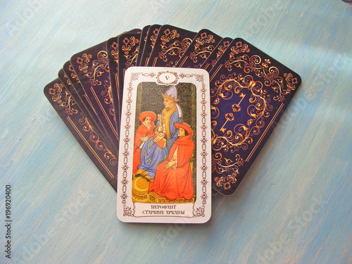 Tarot cards medieval close up with russian title The Hierophant Tarot Decks on blue wooden background photo
