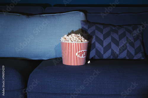 Popcorn on comfortable couch, closeup. Home cinema