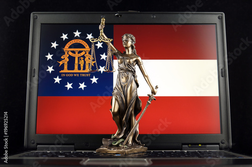 Symbol of law and justice with Georgia State Flag on laptop. Studio shot.