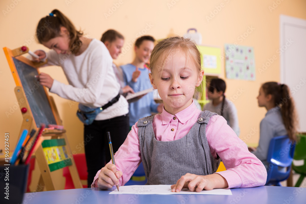 Fototapeta premium Schoolgirl drawing at break in school