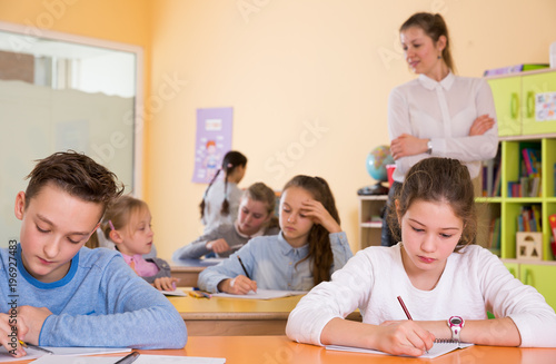 Teacher and pupils working in classroom © JackF
