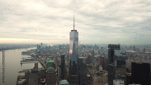Freedom Tower aerial flying moving toward skyscraper in Manhattan New York City with beautiful colorful sunset clouds in sky in 4K and 1080 HD