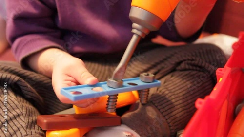 The boy is played by the designer. Child Game. TThe child plays with toy tools.
