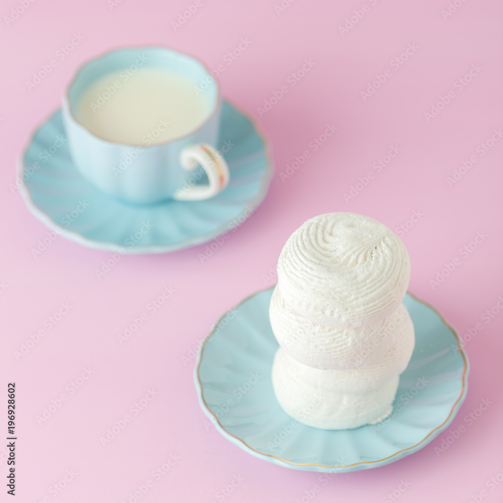 Pastel pink square banner with white zephyr on blue plate and cup of milk. Pastel pink square banner with white zephyr on blue plate and cup of milk.