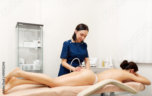 Beautiful woman getting vacuum therapy in beauty salon. photo