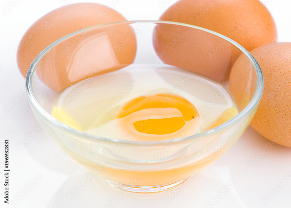 open egg in glass bowl on white background open egg in glass bowl on white background