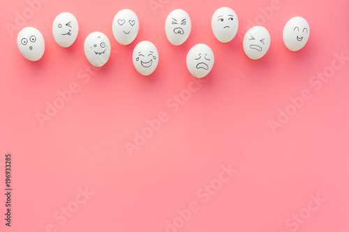 Emotions in communication at social media. Faces drawn on eggs. Happy, smile, sad, angry, in love, saticfied, laughing. Pink background top view copy space