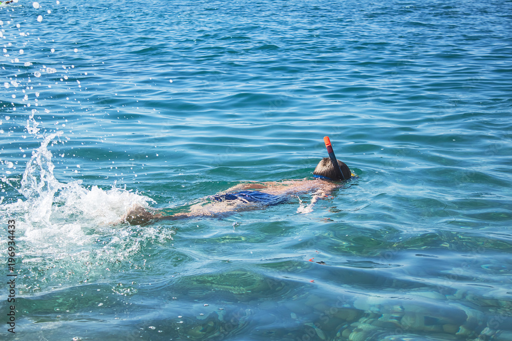 A child snorkelling on the sea
