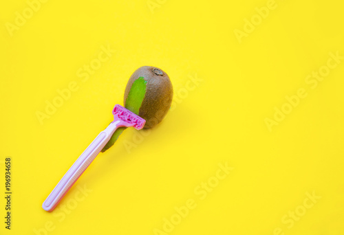Konstfotografi Kiwi fruit and razor on violet and yellow background