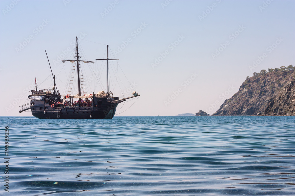 Obraz premium Piękny seascape - widok ranku morze z turystycznym zwiedzającym statkiem w zatoce obok antycznego Phaselis, wybrzeże morze śródziemnomorskie, Antalya prowincja, Turcja.