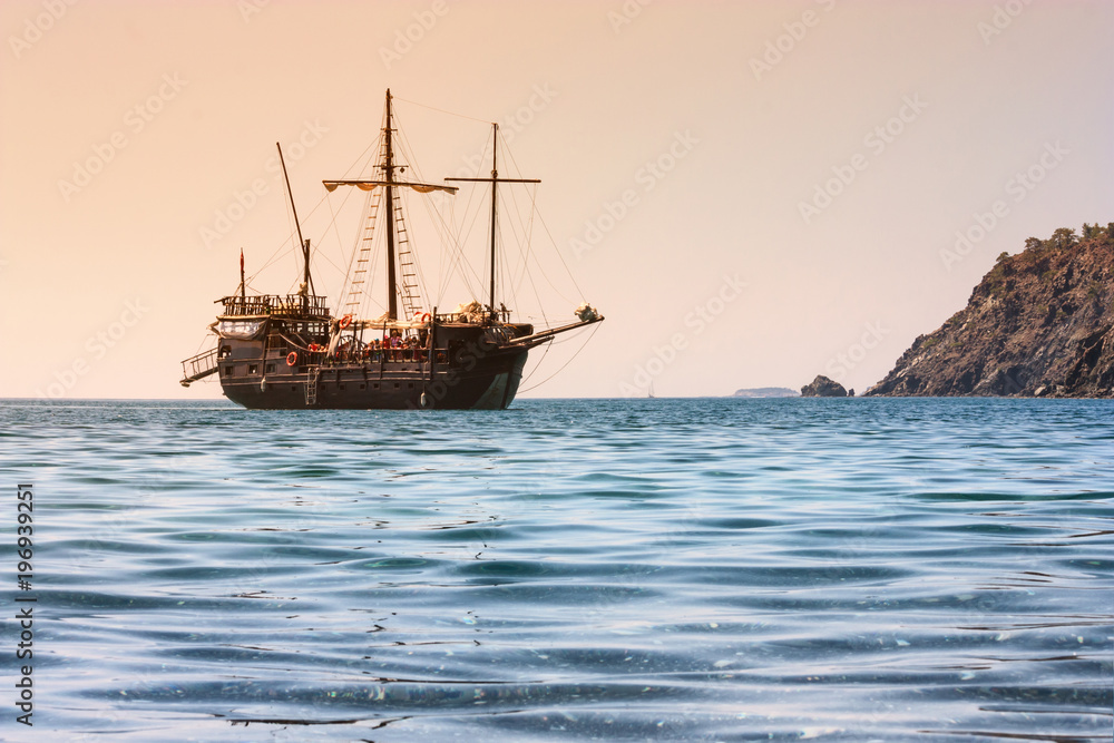 Obraz premium Beautiful seascape - view of morning sea with tourist sightseeing ship in the bay next to of ancient Phaselis, coast of the Mediterranean Sea, Antalya Province, Turkey.