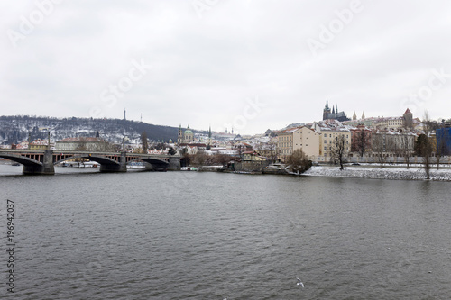 Snowy Prague Lesser Town with gothic Castle above River Vltava, Czech republic