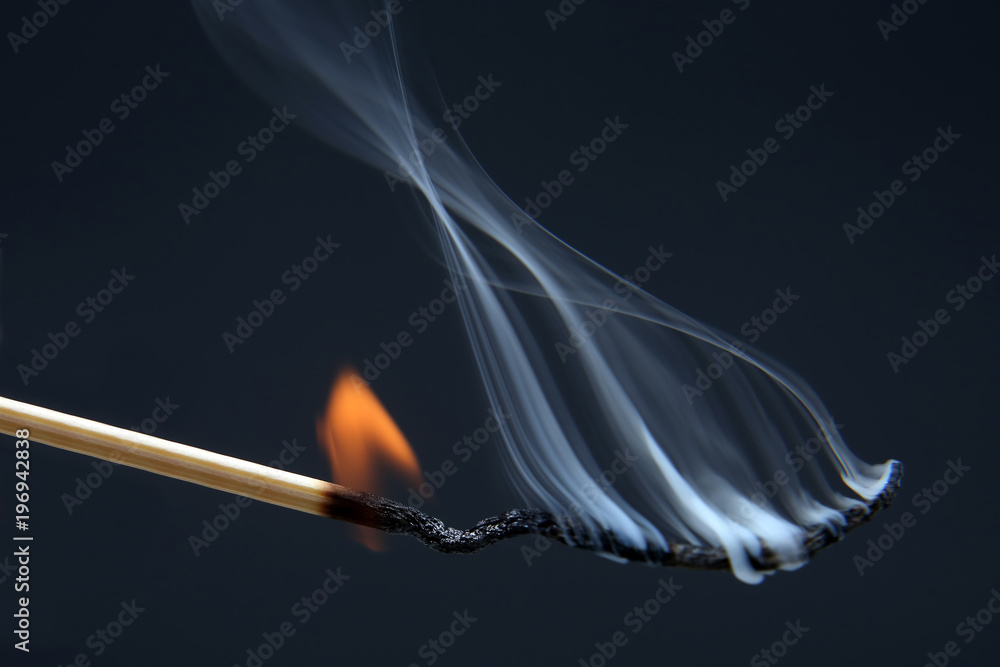 Burning match on a dark blue background Burning match on a dark blue background