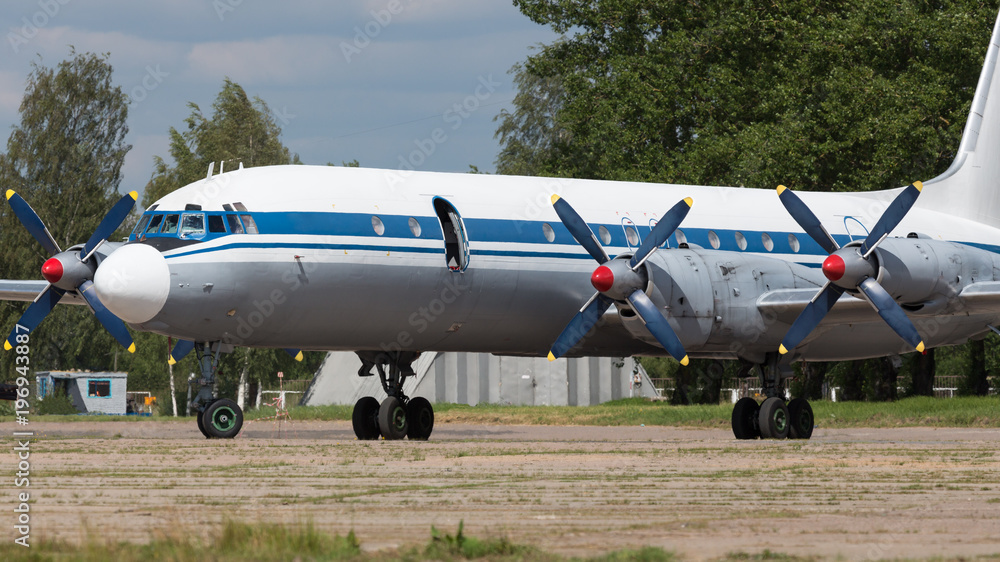 Old soviet civil propeller airliner. Russian turboprop old aircraft parking at the airport. Aviation, air Force concept Old soviet civil propeller airliner. Russian turboprop old aircraft parking at the airport. Aviation, air Force concept