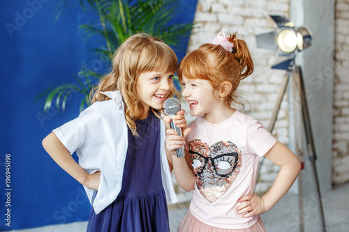 Foto Two funny children sing a song in karaoke