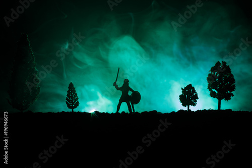 Medieval battle scene with cavalry and infantry. Silhouettes of figures as separate objects, fight between warriors on dark toned foggy background. Night scene. © zef art
