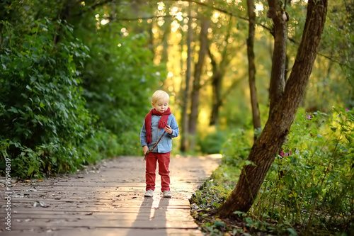 Little boy playing during stroll in the forest