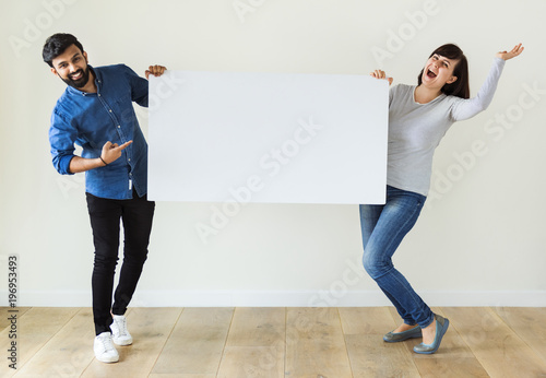 Murais de parede Man and woman holding blank board copyspace