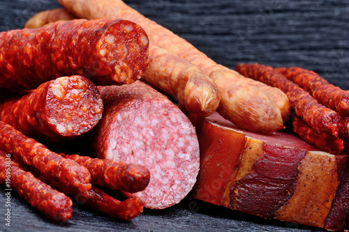 Dried sausages with salami and prosciutto on table