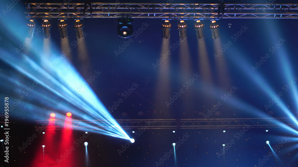 Luminous rays from concert lighting against a dark background over the projector screen, musical instrument concept