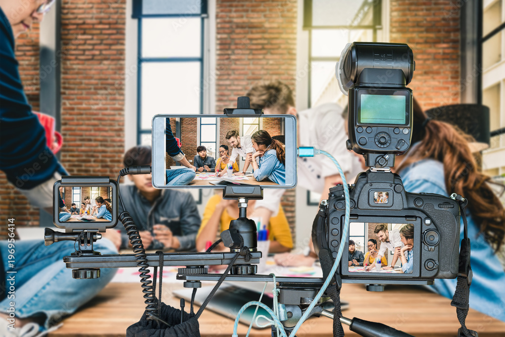 Professional set of camera with smart mobile phone and action camera on tripod over Group Of Asian and Multiethnic Business people working and brainstorming, Live Streaming for entrepreneur concept