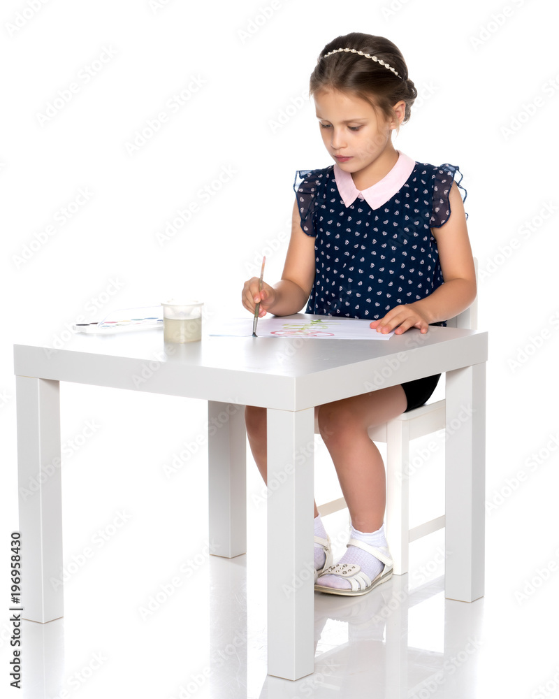 A little girl paints with paint and brush. A little girl paints with paint and brush.