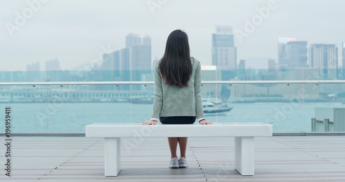Canvas Print Woman sitting at the bench and looking at the view in Hong Kong