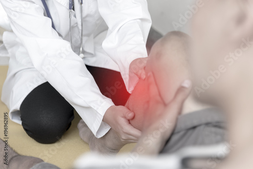 Exercise injury. Doctor help patient who had knee to release pain. Healthcare concept.