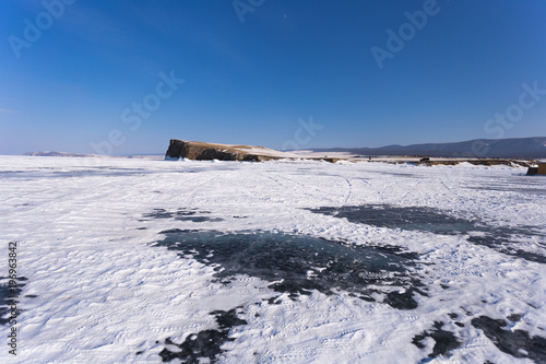 Lake Baikal in winter day. The ice near the cliffs of Haranci Island