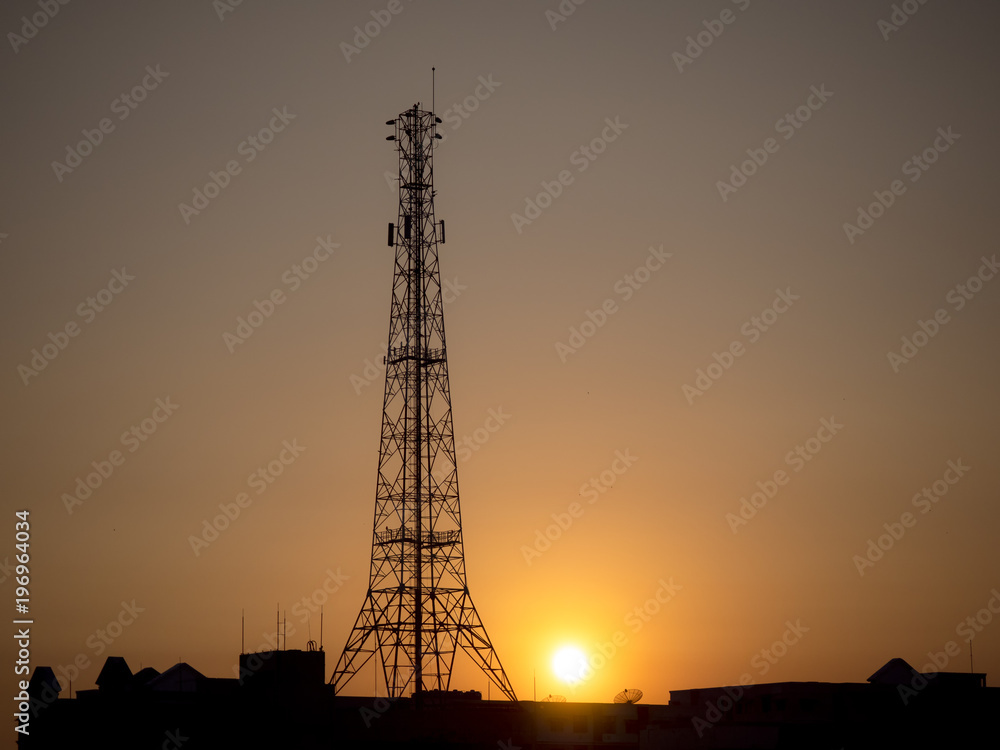 Silhouette high antenna in mid of city as background