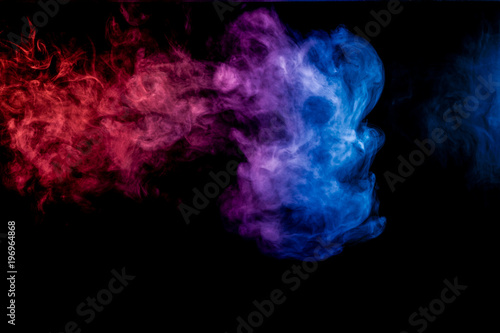 Dense multicolored smoke of blue, red and purple colors on a black isolated background. Background of smoke vape