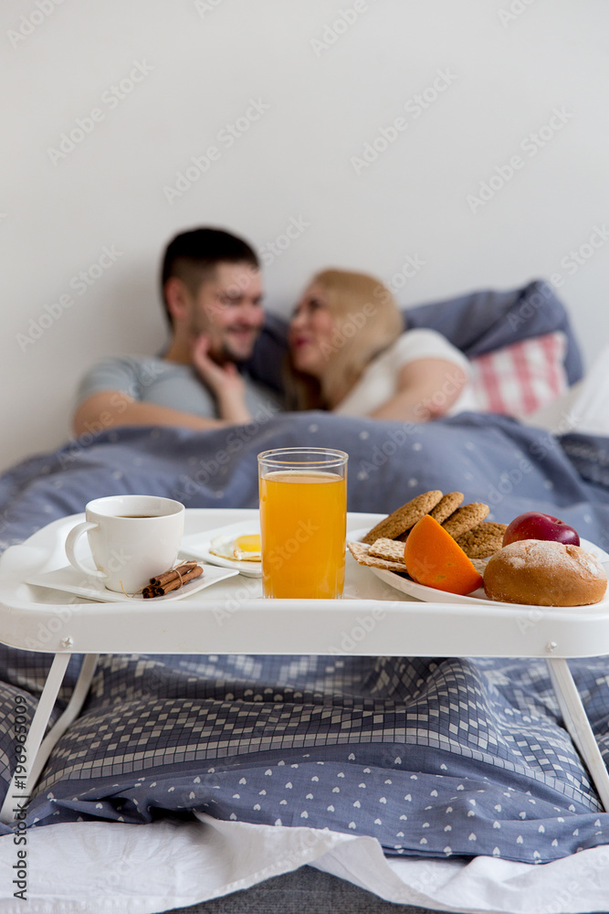 Couple enjoying breakfast in bed Couple enjoying breakfast in bed
