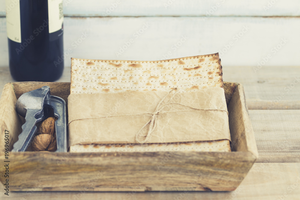 Pack of matzah or matza and Kosher red wine on a vintage wood and blurry or bokeh background.Jewish Passover holiday composition with copy space.