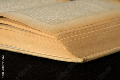 Ein altes, gelbliches Buch auf schwarzem Hintergrund