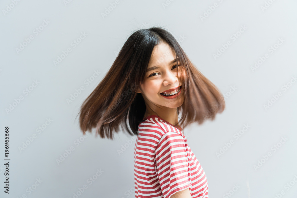 Young girl happy smile and cheerful in red dress in a swirling gesture and hair fluttering along the rotating force. Concept summer travel. Young girl happy smile and cheerful in red dress in a swirling gesture and hair fluttering along the rotating force. Concept summer travel.