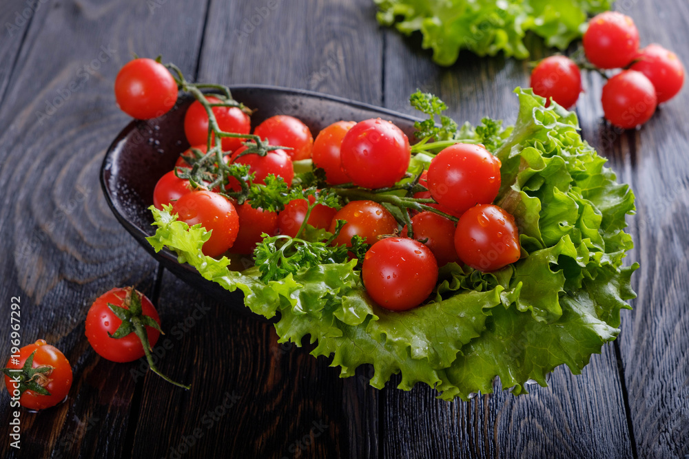 Salad and tomatoes on a black board. Salad and tomatoes on a black board.