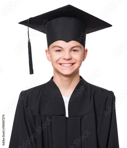 Close up portrait of graduate teen boy student in black graduation gown with hat - isolated on white background. Child back to school and educational concept.