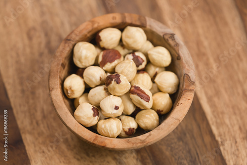 roasted organic hazelnuts in wood bowl on a table