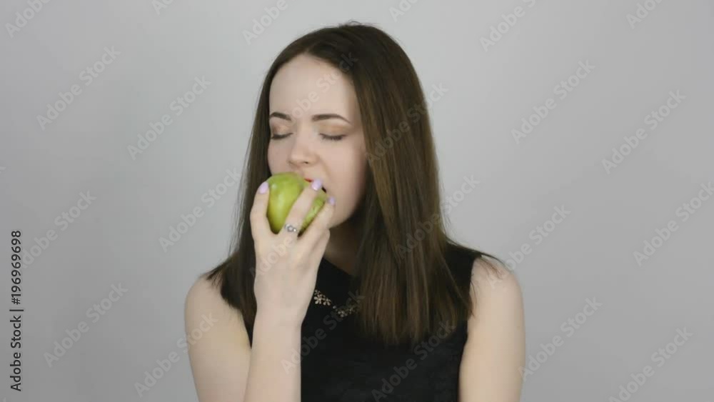 Beautiful young woman eats a green apple. Concept of eating fresh fruits vegetarian Beautiful young woman eats a green apple. Concept of eating fresh fruits vegetarian