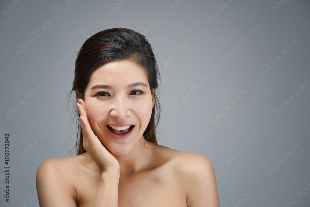 Happy beautiful asian girl with the fresh skin in grey colour background. Expressive facial expressions. Cosmetology and Spa concept. Happy beautiful asian girl with the fresh skin in grey colour background. Expressive facial expressions. Cosmetology and Spa concept.