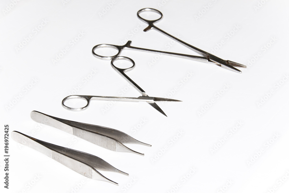 Surgical Instruments (tweezers, pliers, clamp the blade, scalpel, scissors) on a white table. Surgical Instruments (tweezers, pliers, clamp the blade, scalpel, scissors) on a white table.