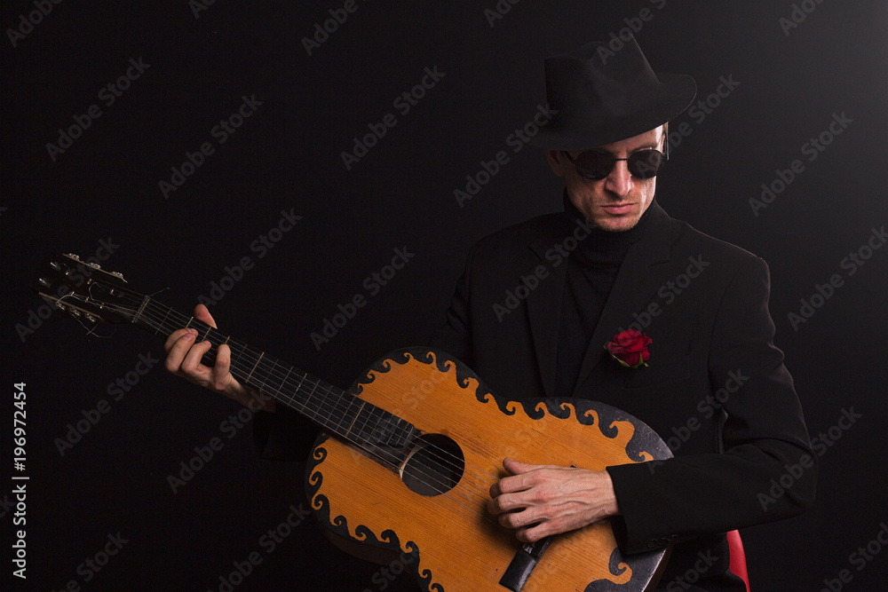 stylish guy in suit with guitar, on black background stylish guy in suit with guitar, on black background