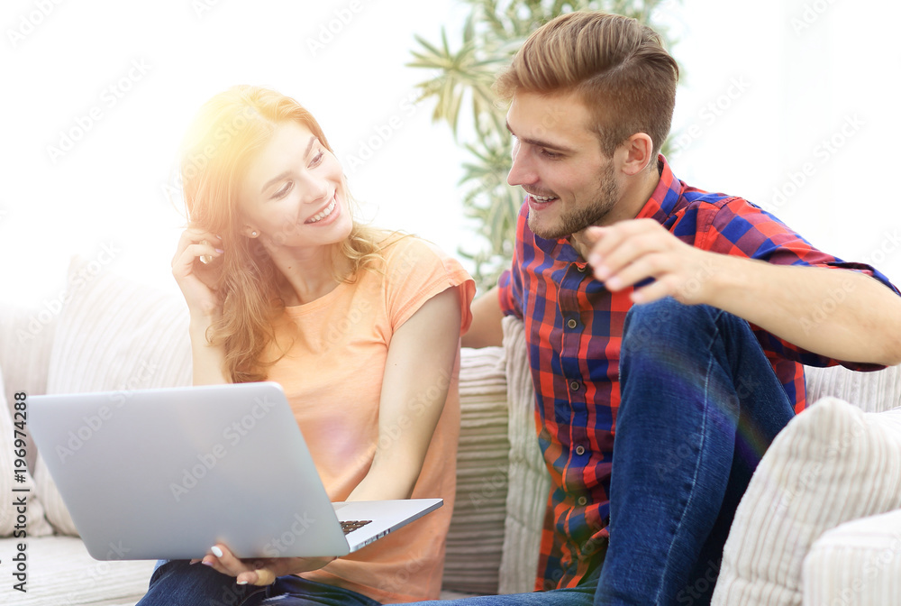 young man and his girlfriend looking at pictures on the laptop. young man and his girlfriend looking at pictures on the laptop.