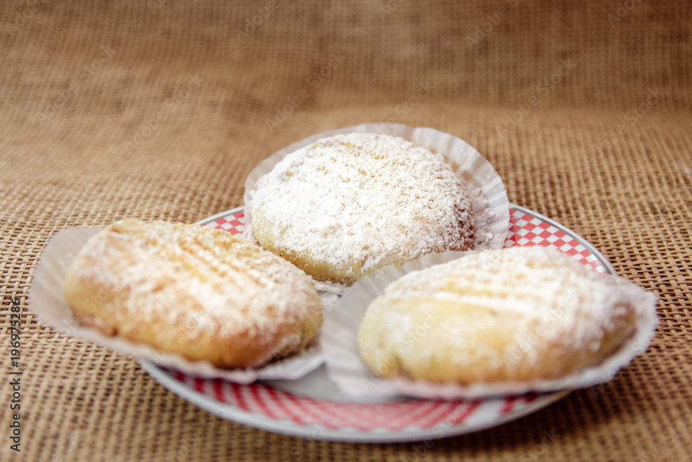 Three Homemade or table food cookies on white plate with burlap textile. Close up shot. Three Homemade or table food cookies on white plate with burlap textile. Close up shot.