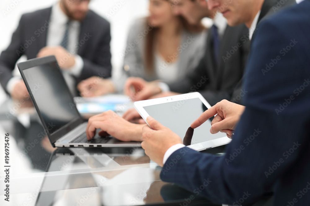 Business man using a tablet while business people talking in th Business man using a tablet while business people talking in th