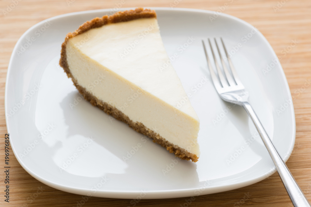 Classic New York cheesecake on white plate. Closeup view, selective focus Classic New York cheesecake on white plate. Closeup view, selective focus