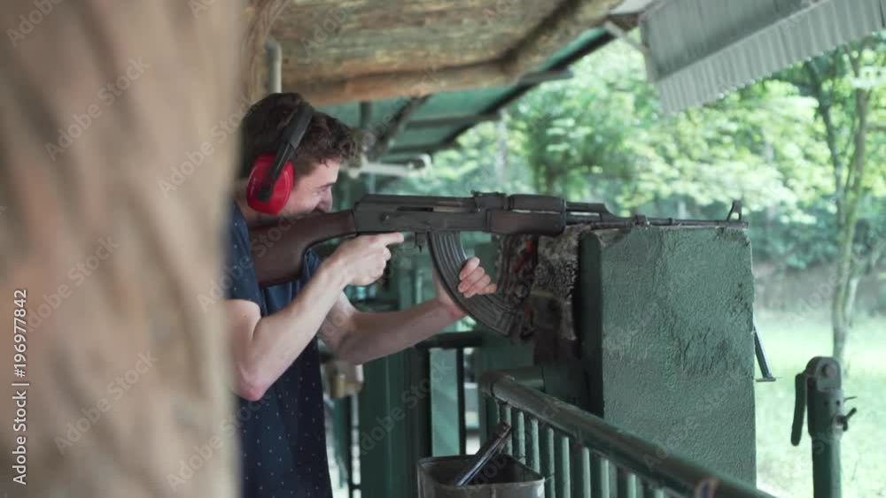 Excited young white male fires machine gun at shooting range at Cu chi tunnels in Vietnam. Excited young white male fires machine gun at shooting range at Cu chi tunnels in Vietnam.