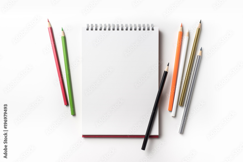 Design concept - Top view of red spiral notebook and many color pencil collection isolated on white background for mockup Design concept - Top view of red spiral notebook and many color pencil collection isolated on white background for mockup