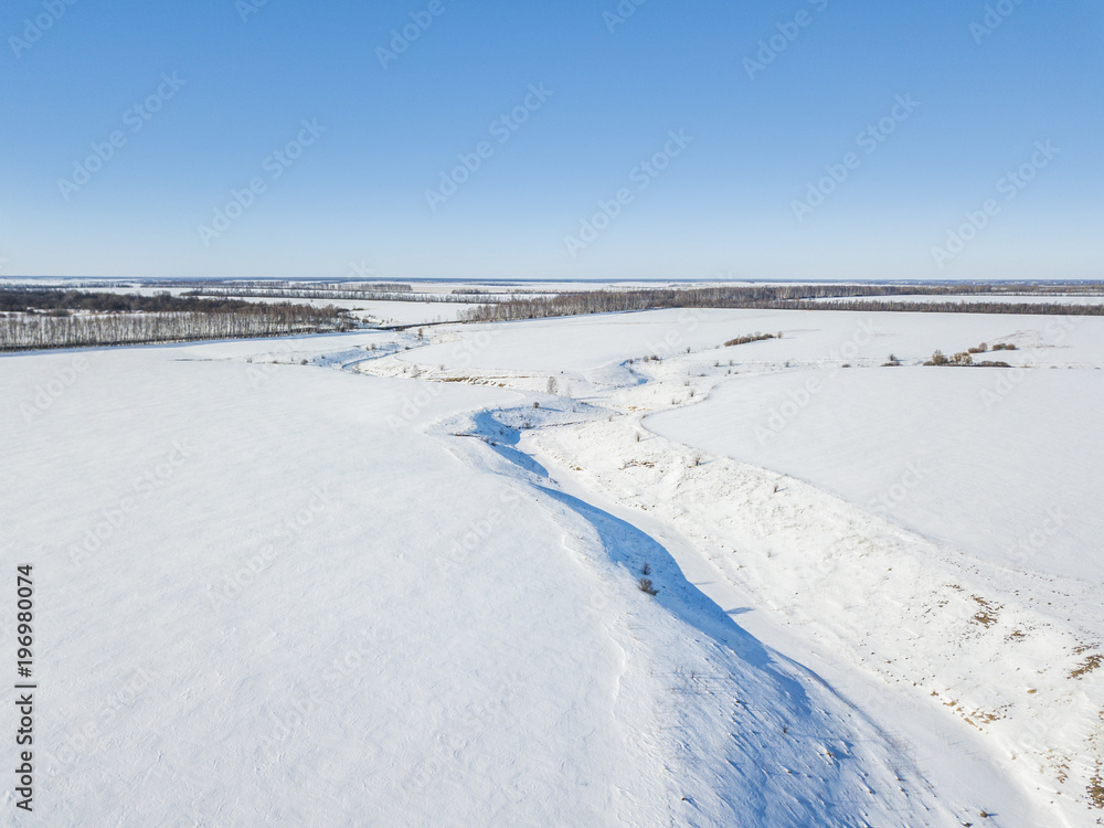 Small frozen river. Ice and snow. Aerial view winter sunny landscape Small frozen river. Ice and snow. Aerial view winter sunny landscape